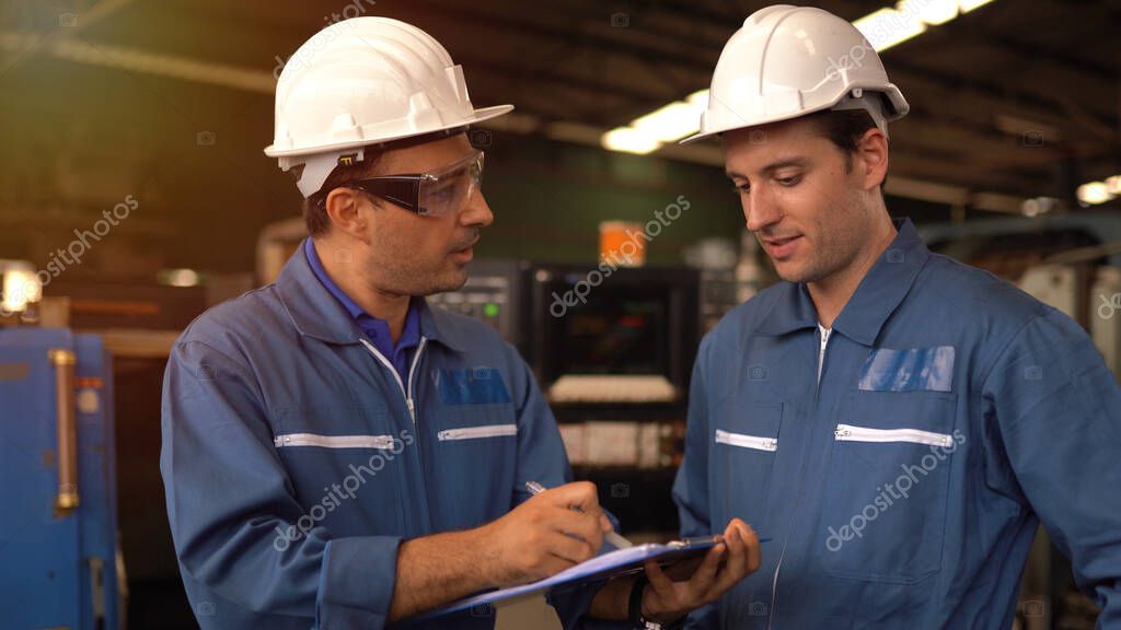 Team aziendale davanti a impianti industriali sicuri